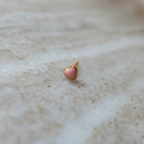  Single Tiny Pink Heart Ørestik: En charmerende ørestik med et lille hjerte, der har en pink overflade og sidder tæt til øreflippen, perfekt til at tilføje romantik og glæde til din smykkesamling.