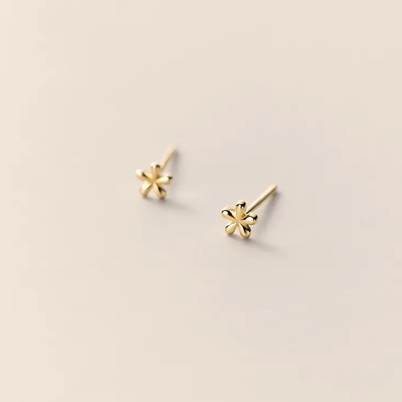 Single Tiny Flora Ørestik: En enkel og yndefuld blomst-ørering, lavet af 925 sterlingsølv og forgyldt med ægte 18 karat guld, der tilføjer subtil elegance til dit look.