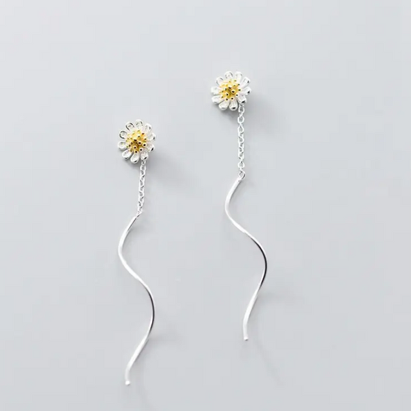 En sølv ørering formet som en blomst med en snoet kæde. Blomsten har et gyldent center og hvide blade, inspireret af en marguerit. Lavet af sterlingsølv og en del af Mille&Lykkes playful kollektion."