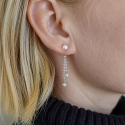 Single Triple Pearl Ørering: En elegant ørering med en perle tæt på øret, to korte kæder hænger ned, hver med en perle for enden. Fremstillet i høj kvalitet 925 sterlingsølv, tilføjer denne ørering subtil glamour og bevægelse til din stil.