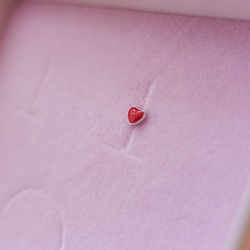 Single Tiny Red Heart Ørestik: En stilfuld ørestik med et lille hjerte, der har en rød overflade og sidder tæt til øreflippen, perfekt til at tilføje farve og kærlighed til din smykkesamling.