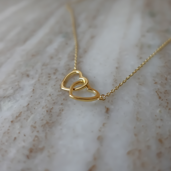 You and Me Halskæde: En smuk halskæde med et vedhæng i form af to hjerter, der symboliserer en unik forbindelse, lavet af 925 sterlingsølv og forgyldt med ægte 18 karat guld.
