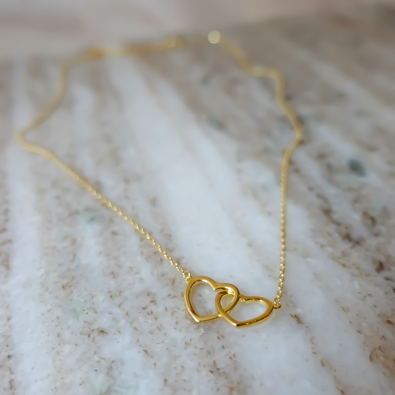 You and Me Halskæde: En smuk halskæde med et vedhæng i form af to hjerter, der symboliserer en unik forbindelse, lavet af 925 sterlingsølv og forgyldt med ægte 18 karat guld.