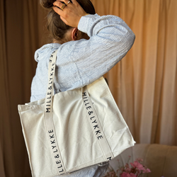 Tote bag i kraftigt kanvas fra MilleogLykke. Beige tote bag med MilleogLykke logo på stroppen