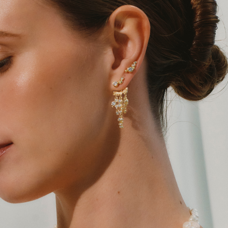 Forgyldt behind ear vedhæng fra Milleoglykke. Behind ear ørering med 3 vedhæng, i forskellige længder, hver fyldt med hvide zirkoner. 