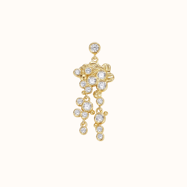 Ørering med et stik. på Ørestikken sidder en zirconiasten omkranser af en guld belægning. Øreringen har et stor vedhæng som er en blandet af guld og zirconiasten der sidder asymmetrisk. på det store vedhænd er der yderligere to vedhæng der falder ned fra med en blanding af guld kugler og zirconiasten 