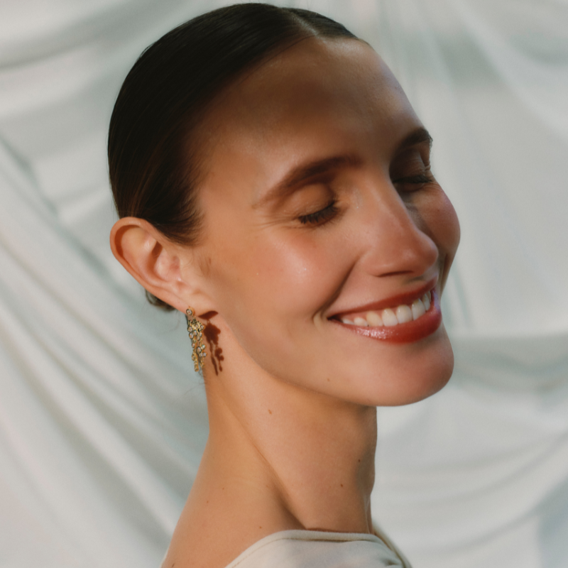 Ørering med et stik. på Ørestikken sidder en zirconiasten omkranser af en guld belægning. Øreringen har et stor vedhæng som er en blandet af guld og zirconiasten der sidder asymmetrisk. på det store vedhænd er der yderligere to vedhæng der falder ned fra med en blanding af guld kugler og zirconiasten 